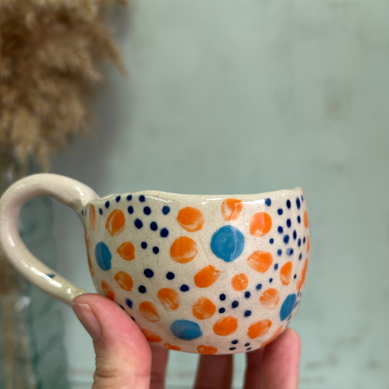 Taza pequeña con flores naranjas y azules hecha por paula molina art en granada